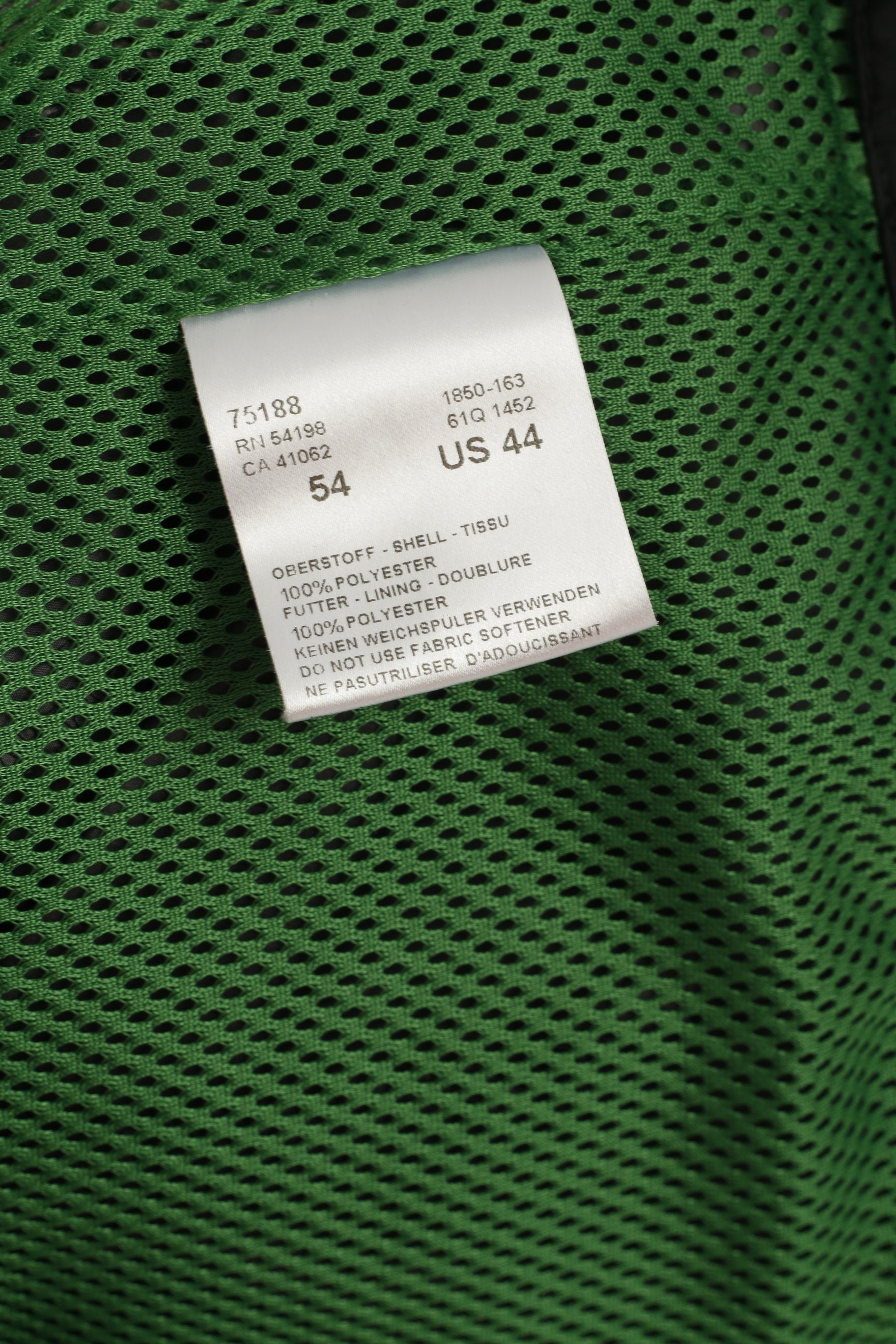 Close-up of a green textured fabric with a white label displaying text and numbers.