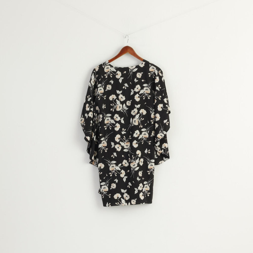 Black dress with floral pattern on a hanger against a white background