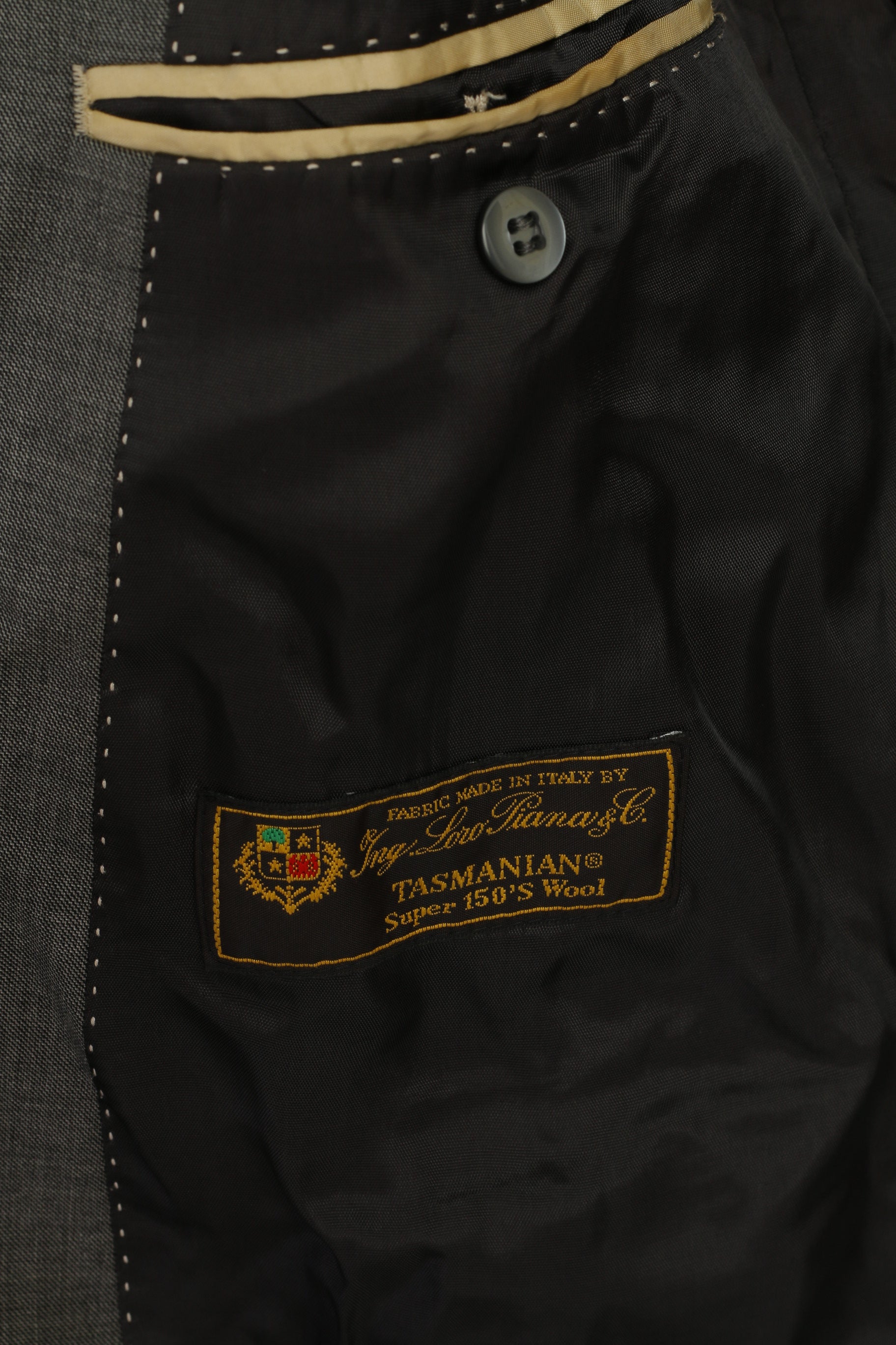 Close-up of a label on a black garment with visible stitching details.