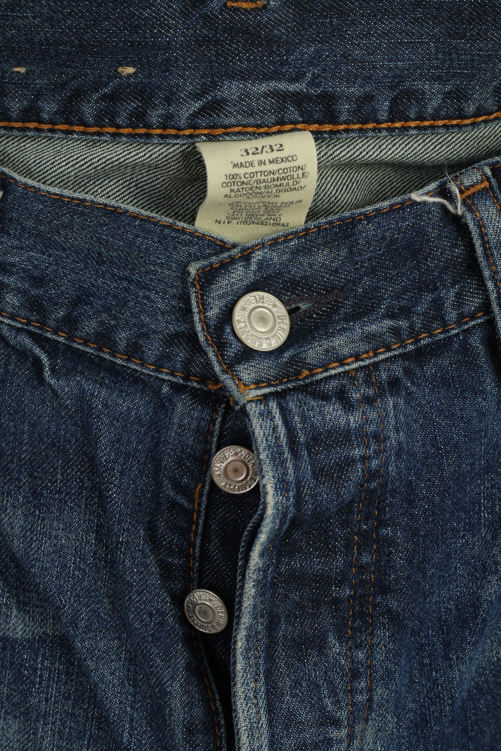 Close-up of a blue denim jacket with buttons and a label.