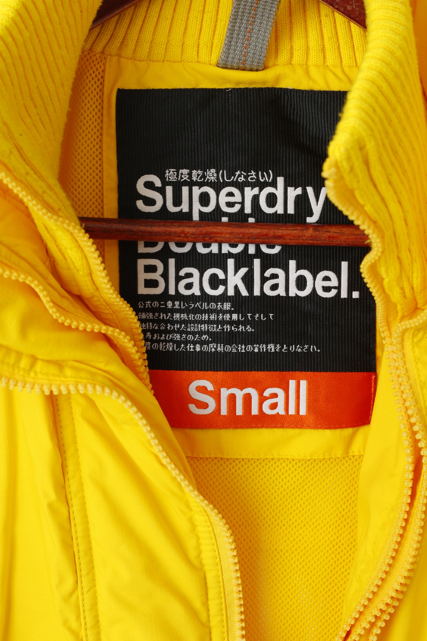 Giacca da donna Superdry gialla con doppia etichetta nera in nylon con 3 cerniere e parte superiore leggera